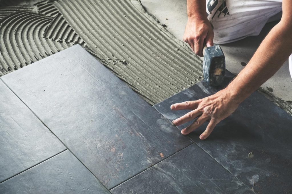 Builder adding tiles to the floor